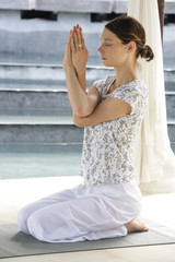 Woman with eyes closed sitting in lotus yoga position