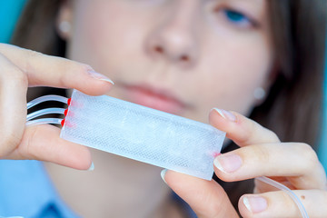 Girl holding polymers Bio-MEMS biomedical microelectromechanical systems / LOC lab-on-a-chip device...