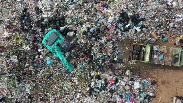 Garbage pile in trash dump or open landfill, Trash trucks dump waste products polluting in an trash dump, Surface and subsurface water contamination, modern hydraulic. Aerial top view