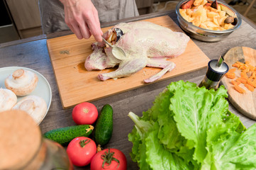 Close-up of female hands preparing duck or goose for baking. White carrot dressing with mayonnaise. Christmas dish duck goose with apples
