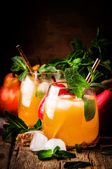Cold pear juice, iced summer non-alcoholic cocktail with mint, old wooden table background,...