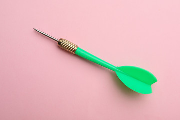 Green dart arrow on pink background, top view