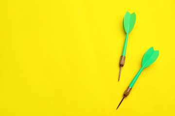Green dart arrows on yellow background, flat lay with space for text
