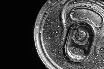Aluminum can of beverage covered with water drops on black background, top view. Space for text