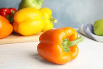 Fresh ripe bell peppers on wooden table
