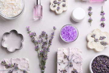 Fototapeta na wymiar Flat lay composition with hand made soap bars and lavender flowers on light stone surface