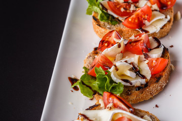 Bruschetta with tomatoes, lettuce, camambert, balsamic vinegar