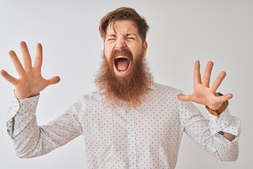 Young redhead irish man wearing shirt standing over isolated white background celebrating mad and...