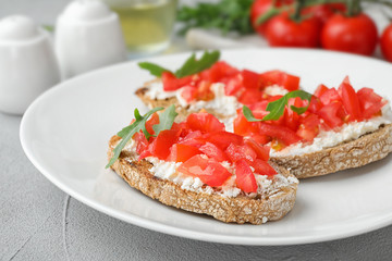 Plate of delicious tomato bruschettas on table, closeup