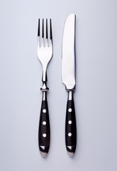 Messer und Gabel isoliert auf  einer Tischplatte