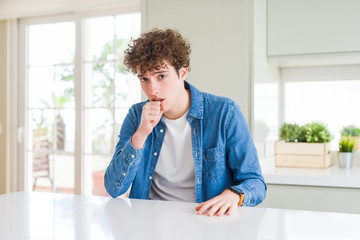 Young handsome man wearing casual denim jacket at home feeling unwell and coughing as symptom for cold or bronchitis. Healthcare concept.