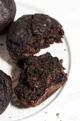 delicious chocolate muffins on a plate, top view in a cut