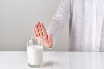 woman with lactose intolerance refusing glass of milk