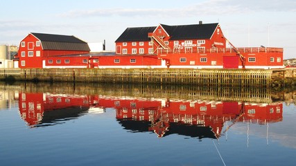 Casa de madera color rojo reflej&aacute;ndose en el agua,islas Lofoten, Noruegaa