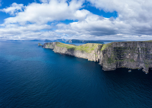 Panoramic aerial view from Sandoy island cliffs and rock stacks under the clouds, Faroe Islands