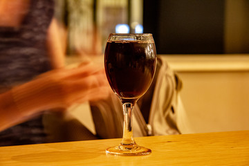 sweating glass of red wine on wooden table