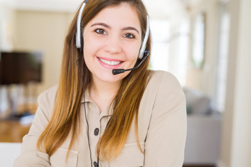 Beautiful young operator woman wearing headset at the office with a happy and cool smile on face....
