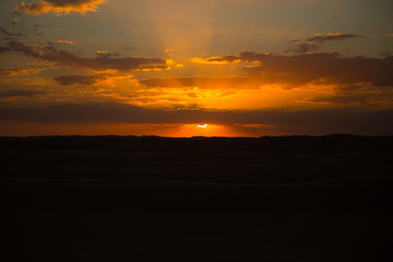 beautiful sunset colors, sun peaking into clouds 