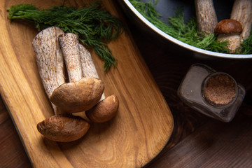 wooden tray with porcini mushrooms on a wooden table. Ingredients before cooking.