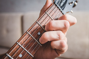 Dm chord - close-up male Caucasian hand takes a chord on a 6 string guitar