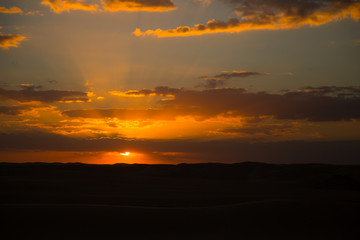 beautiful sunset colors, sun peaking into clouds 