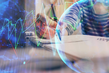 Financial forex graph drawn over hands taking notes background. Concept of research. Double exposure