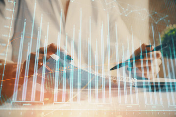 Financial chart drawn over hands taking notes background. Concept of research. Multi exposure