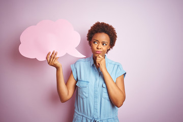 Young african american woman holding speech bubble over pink isolated background serious face thinking about question, very confused idea