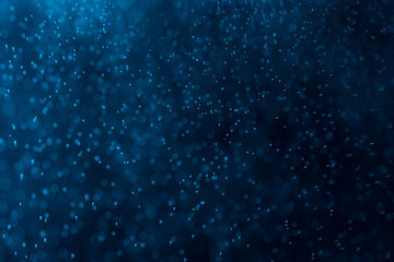 splashes of water or snow on a dark background with a blue tint