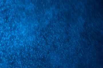 splashes of water or snow on a dark background with a blue tint