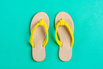 Eco yellow bamboo flip flops on mentol green background Flat lay, top view. Zero waste, plastic...