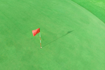 top view of golf pole on the green in a golf course with blank copyspace
