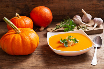 bowl of pumpkin soup with ingredients for cooking