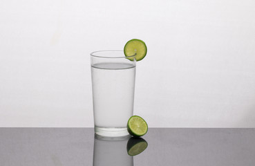 A glass of water with lemon and lime