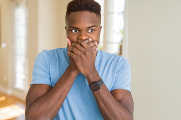 Handsome african american man wearing casual t-shirt shocked covering mouth with hands for mistake. Secret concept.