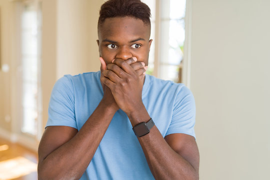 Handsome african american man wearing casual t-shirt shocked covering mouth with hands for mistake. Secret concept.