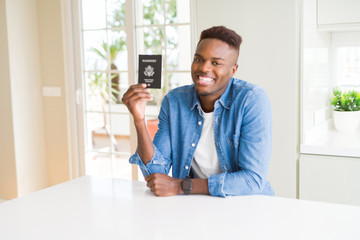 African american man holding passport of United States of America with a happy face standing and smiling with a confident smile showing teeth