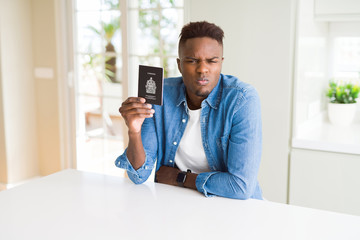 African american man holding passport of Canada with a confident expression on smart face thinking serious