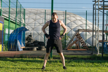 man doing warm-up before strength training outdoors on green grass