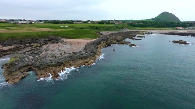 View on the green agricultural fields, Milsey Bay and Haugh Road Beach from above, North Sea, North Berwick, East Lothian, Scotland. Aerial view drone