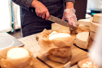 Seller prepares cheese for the custumers at cheese festival. Organic and farm food