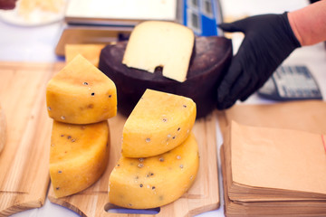 Seller prepares cheese for the custumers at cheese festival. Organic and farm food