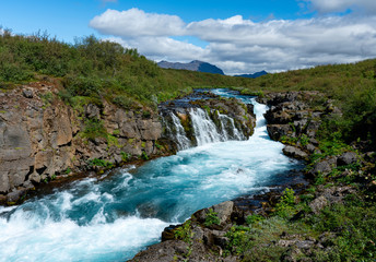 Waterfall and glacial blue water in Iceland