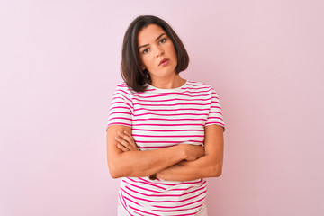 Young beautiful woman wearing striped t-shirt standing over isolated pink background looking sleepy and tired, exhausted for fatigue and hangover, lazy eyes in the morning.