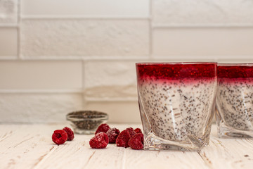 Greek yogurt and chia seeds for breakfast with raspberry sorbet. In a glass on a wooden white background.