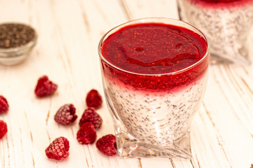 Greek yogurt and chia seeds for breakfast with raspberry sorbet. In a glass on a wooden white background.