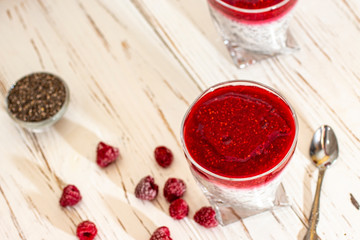 Greek yogurt and chia seeds for breakfast with raspberry sorbet. In a glass on a wooden white background.