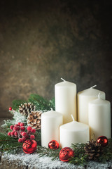 Christmas decoration with white candles on wooden background