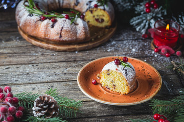 Obraz na płótnie Canvas Traditional homemade christmas cake holiday dessert with cranberry and chocolate with new year tree decoration on vintage wooden table background.