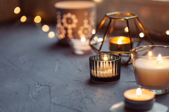 Candles of various shapes on the windowsill. Cozy home concept, close-up